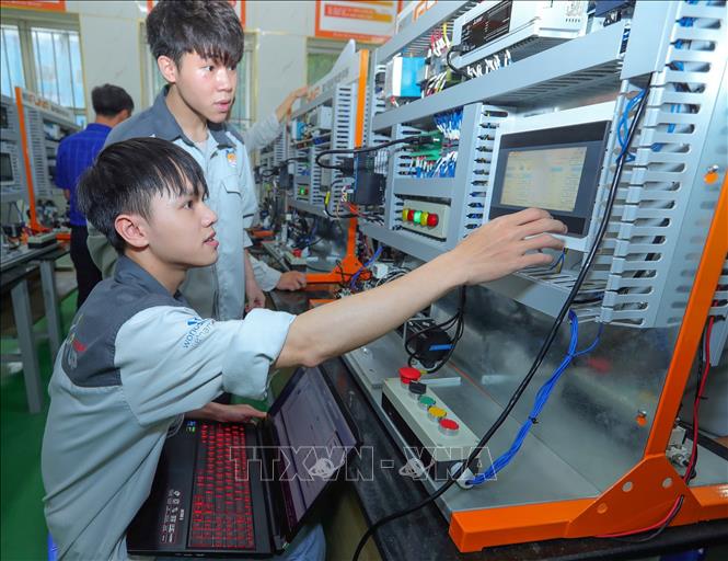 Sinh viên lớp FUNA D đang thực hành môn PLC trong Trung tâm đào tạo sản xuất thông minh HNIVC-FUNA. Ảnh: Hoàng Hiếu - TTXVN