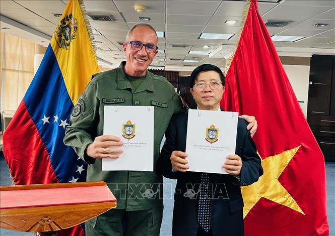 Thượng tướng, Hiệu trưởng UNEFA Pascualino Angiolillo và Hiệu trưởng UTM Nguyễn Xuân Sơn ký Ý định thư hợp tác giữa hai trường. Ảnh: TTXVN/phát