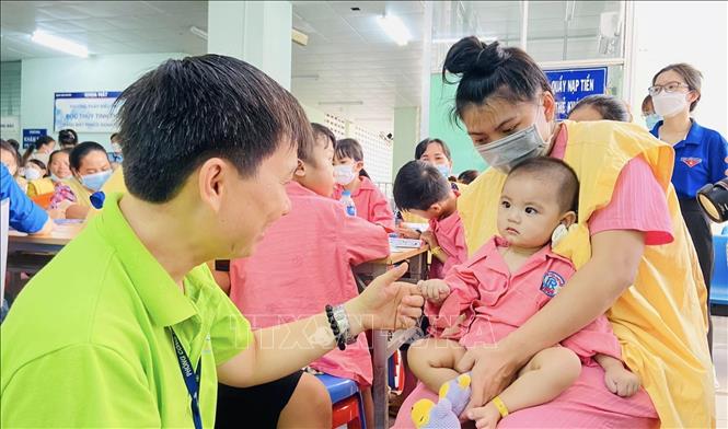 Trong ảnh: Thạc sĩ Lê Minh Hiển và khoảnh khắc vui vẻ bên một bệnh nhi điều trị tại Bệnh viện Chợ Rẫy. Ảnh: TTXVN phát