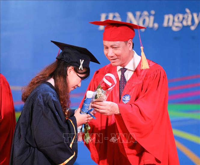 PGS.TS Nguyễn Đức Sơn, Phó hiệu trưởng Trường Đại học Sư phạm Hà Nội tặng hoa chúc mừng các tân cử nhân K69 tốt nghiệp xuất sắc. Ảnh: Thanh Tùng - TTXVN