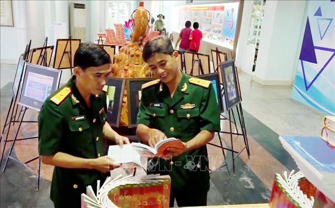 Thiếu tá Nguyễn Văn Ca Răn (bêntrái) tại triển lãm sách chuyên đề về học tập và làm theo tư tưởng, đạo đức, phong cách Hồ Chí Minh tại thành phố Long Xuyên, tỉnh An Giang. Ảnh: TTXVN phát