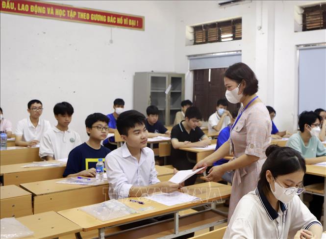 Thí sinh nhận giấy thi tại điểm thi THPT Trần Phú, thành phố Vĩnh Yên - Ảnh: Hoàng Hùng - TTXVN