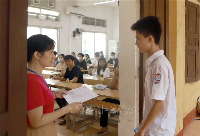 Giám thị gọi thí sinh vào phòng thi tại điểm thi THPT Trần Phú, thành phố Vĩnh Yên - Ảnh: Hoàng Hùng - TTXVN