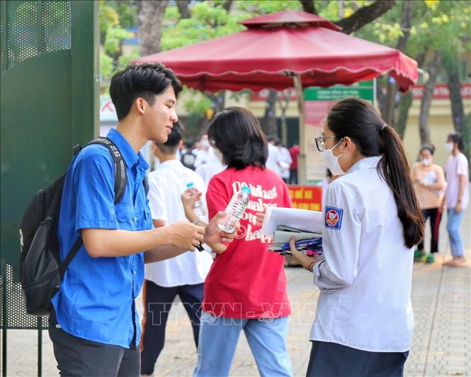 Thanh niên tình nguyện phát nước cho thí sinh tại điểm thi trường THPT Nguyễn Gia Thiều (quận Long Biên). Ảnh: Tuấn Đức - TTXVN