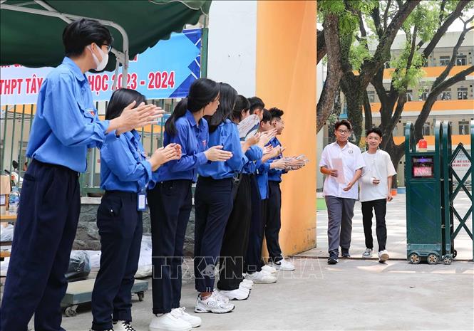 Thanh niên tình nguyện cổ vũ, động viên tinh thần thí sinh sau giờ thi căng thẳng. Ảnh: Thanh Tùng - TTXVN 