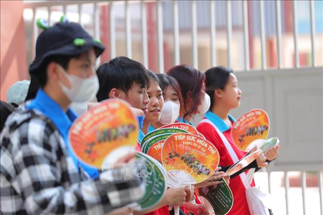 Tình nguyện viên tiếp sức mùa thi tại điểm thi Trường THPT Trương Định. Ảnh: Hoàng Hiếu - TTXVN 
