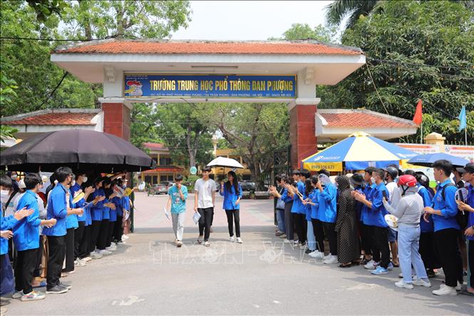 Thanh niên tình nguyện chào đón thí sinh điểm thi Trường THPT Đan Phượng hoàn thành môn thi Toán. Ảnh: Hoàng Hiếu - TTXVN 