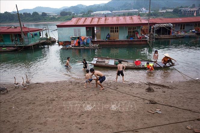 Trong ảnh: Lượng nước sông Đà phía hạ lưu thuỷ điện Hoà Bình cạn nước đã đẩy những ngôi nhà nổi ở xóm vạn chài dưới chân cầu Hoà Bình 3 thêm xa bờ. Ảnh: Trọng Đạt - TTXVN