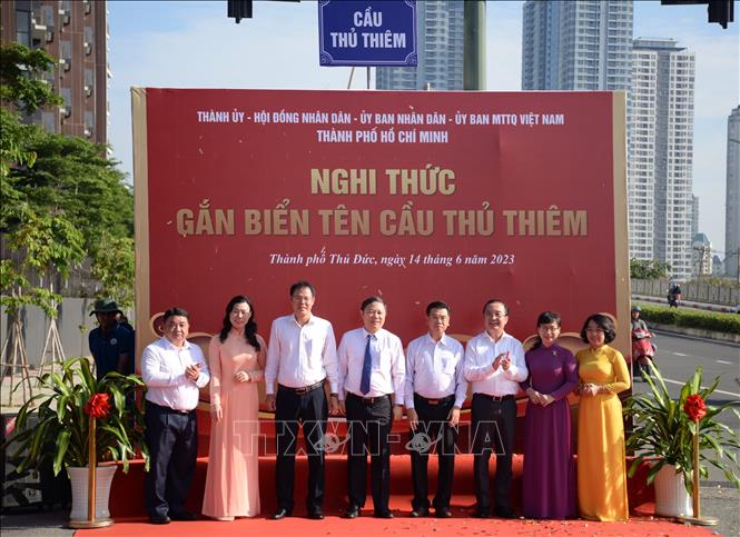 Trong ảnh: Các đại biểu thực hiện nghi thức gắn biển tên cầu Thủ Thiêm. Ảnh: Thu Hương - TTXVN