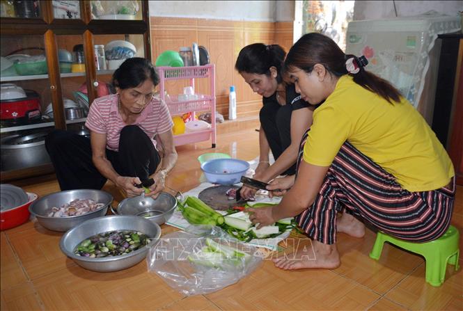 Bà H Juaih Mlô (trái), buôn Pứk Prông, xã Ea Ning, huyện Cư Kuin, tỉnh Đắk Lắk cùng các con đang chuẩn bị để nấu cơm trưa hỗ trợ tổ chốt chặn trong buôn. Ảnh: Hoài Thu – TTXVN