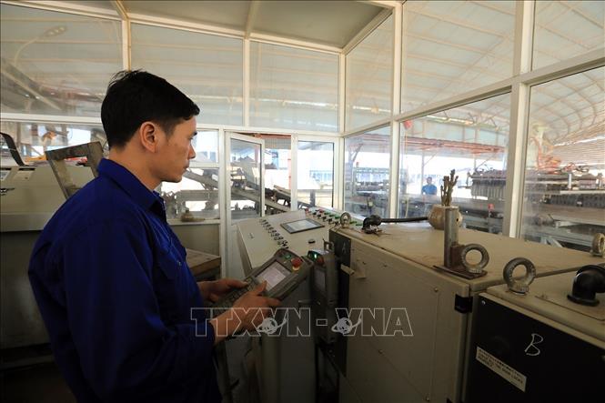 Công nhân điều khiển robot tự động xếp gạch theo quy trình tự động hóa. Ảnh: Tuấn Anh - TTXVN