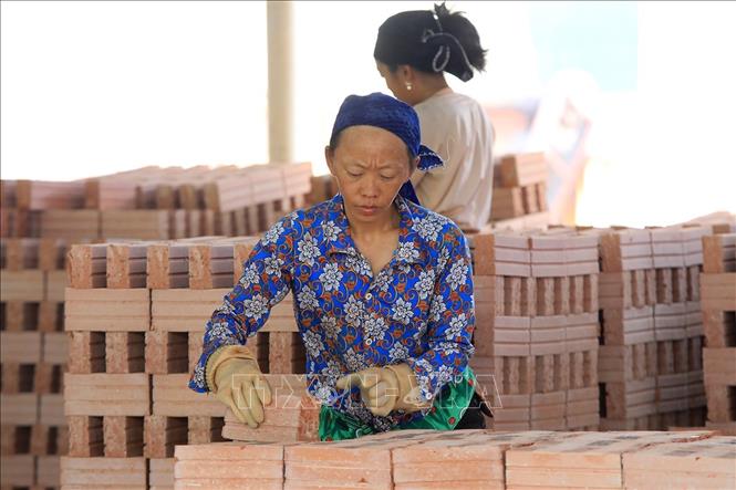 Công nhân bốc dỡ gạch sau khi đã được nung. Ảnh: Tuấn Anh - TTXVN