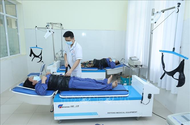 Trong ảnh: Các bệnh nhân được sử dụng phương pháp kéo giãn cột sống tại Bệnh viên Y học cổ truyền tỉnh Lạng Sơn. Ảnh: Anh Tuấn - TTXVN