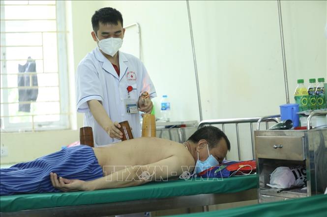 Trong ảnh: Sử dụng phương pháp Giác hơi điều trị cho bệnh nhân. Ảnh: Anh Tuấn - TTXVN