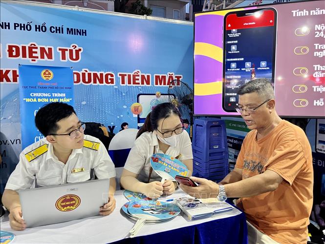 Trong ảnh: Người dân tham gia trải nghiệm các dịch vụ thanh toán không tiền mặt tại gian hàng của Cục Thuế Tp. Hồ Chí Minh. Ảnh: Hứa Chung - TTXVN