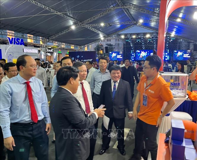 Trong ảnh: Lãnh đạo UBND Tp. Hồ Chí Minh và Ngân hàng Nhà nước tham quan các gian hàng triển lãm tại Lễ hội Cashless Town. Ảnh: Hứa Chung - TTXVN