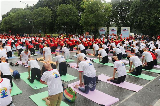 Đồng diễn Yoga tại khu vực phố đi bộ Hồ Hoàn Kiếm sáng 18/6. Ảnh: TTXVN phát