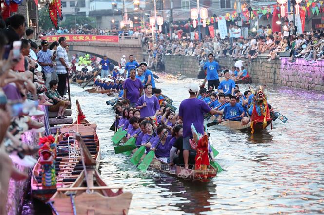 Hàng năm, cứ đến Tết Đoan Ngọ (5/5 âm lịch), người dân Trung Quốc lại tổ chức lễ hội Thuyền rồng trên khắp đất nước để cầu bình an và xua đuổi tà ma, bệnh tật... Điểm nổi bật của lễ hội là cuộc đua thuyền rồng trên sông. Các nhóm chèo thuyền sẽ đua nhau quyết liệt cùng nhịp trống vang dội cả khúc sông. Trong ảnh: Người dân tham gia lễ hội thuyền rồng, tại Phúc Châu, tỉnh Phúc Kiến ngày 20/6/2023. Ảnh: THX/TTXVN