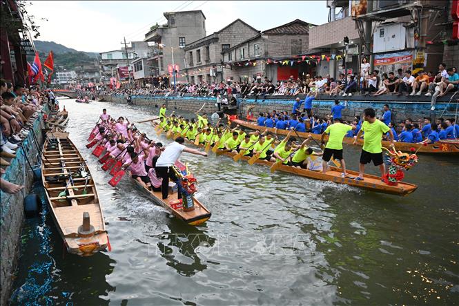 Hàng năm, cứ đến Tết Đoan Ngọ (5/5 âm lịch), người dân Trung Quốc lại tổ chức lễ hội Thuyền rồng trên khắp đất nước để cầu bình an và xua đuổi tà ma, bệnh tật... Điểm nổi bật của lễ hội là cuộc đua thuyền rồng trên sông. Các nhóm chèo thuyền sẽ đua nhau quyết liệt cùng nhịp trống vang dội cả khúc sông. Trong ảnh: Người dân tham gia lễ hội thuyền rồng, tại Phúc Châu, tỉnh Phúc Kiến ngày 20/6/2023. Ảnh: THX/TTXVN