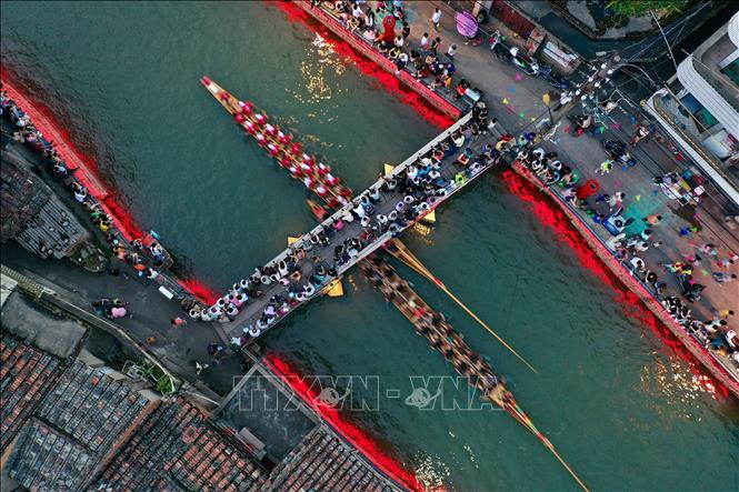 Hàng năm, cứ đến Tết Đoan Ngọ (5/5 âm lịch), người dân Trung Quốc lại tổ chức lễ hội Thuyền rồng trên khắp đất nước để cầu bình an và xua đuổi tà ma, bệnh tật... Điểm nổi bật của lễ hội là cuộc đua thuyền rồng trên sông. Các nhóm chèo thuyền sẽ đua nhau quyết liệt cùng nhịp trống vang dội cả khúc sông. Trong ảnh: Người dân tham gia lễ hội thuyền rồng, tại Phúc Châu, tỉnh Phúc Kiến ngày 18/6/2023. Ảnh: THX/TTXVN