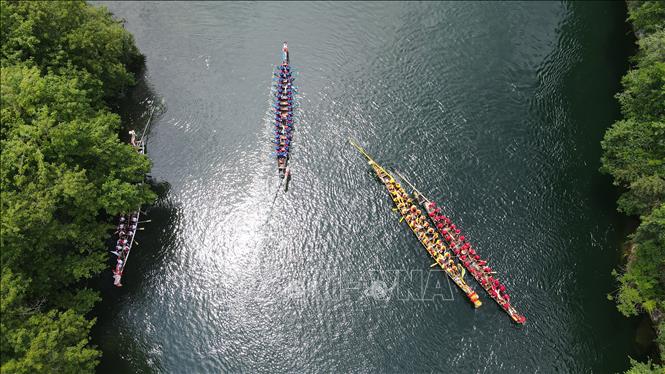 Hàng năm, cứ đến Tết Đoan Ngọ (5/5 âm lịch), người dân Trung Quốc lại tổ chức lễ hội Thuyền rồng trên khắp đất nước để cầu bình an và xua đuổi tà ma, bệnh tật... Điểm nổi bật của lễ hội là cuộc đua thuyền rồng trên sông. Các nhóm chèo thuyền sẽ đua nhau quyết liệt cùng nhịp trống vang dội cả khúc sông. Trong ảnh: Người dân tham gia lễ hội thuyền rồng tại tỉnh An Huy, Trung Quốc ngày 21/6/2023. Ảnh: THX/TTXVN
