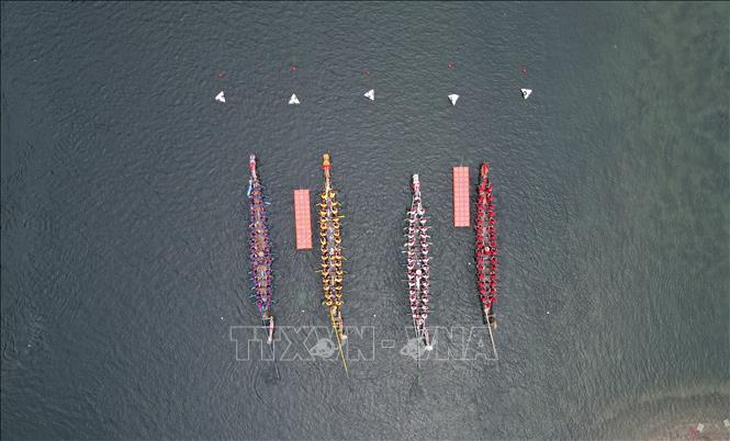 Hàng năm, cứ đến Tết Đoan Ngọ (5/5 âm lịch), người dân Trung Quốc lại tổ chức lễ hội Thuyền rồng trên khắp đất nước để cầu bình an và xua đuổi tà ma, bệnh tật... Điểm nổi bật của lễ hội là cuộc đua thuyền rồng trên sông. Các nhóm chèo thuyền sẽ đua nhau quyết liệt cùng nhịp trống vang dội cả khúc sông. Trong ảnh: Người dân tham gia lễ hội thuyền rồng tại tỉnh An Huy, Trung Quốc ngày 21/6/2023. Ảnh: THX/TTXVN