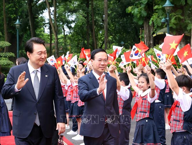 Ha Noi children wave President of the Republic of Korea Yoon Suk Yeol at an official welcome ceremony for them in Ha Noi on June 23. VNA Photo