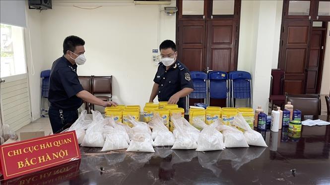 Các túi tinh thể màu trắng nghi ketamin được phát hiện bên trong các hộp sản phẩm. Ảnh: TTXVN phát