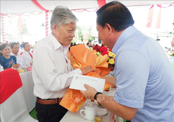 Chủ tịch Ủy ban nhân dân tỉnh Long An Nguyễn Văn Út tặng hoa cho Anh hùng lực lượng vũ trang nhân dân Nguyễn Văn Minh. Ảnh: Đức Hạnh - TTXVN 