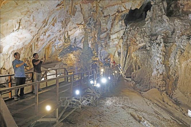 Trong ảnh: Du khách lưu lại vẻ đẹp của hang động trong Động Thiên Đường. Ảnh: Trần Việt - TTXVN