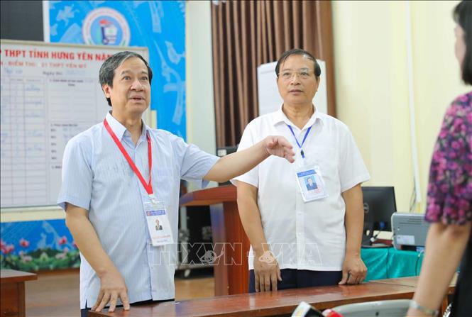 Bộ trưởng Bộ Giáo dục và Đào tạo Nguyễn Kim Sơn trao đổi với cán bộ coi thi tại điểm thi Trường THPT Yên Mỹ (huyện Yên Mỹ, Hưng Yên). Ảnh: Thanh Tùng - TTXVN