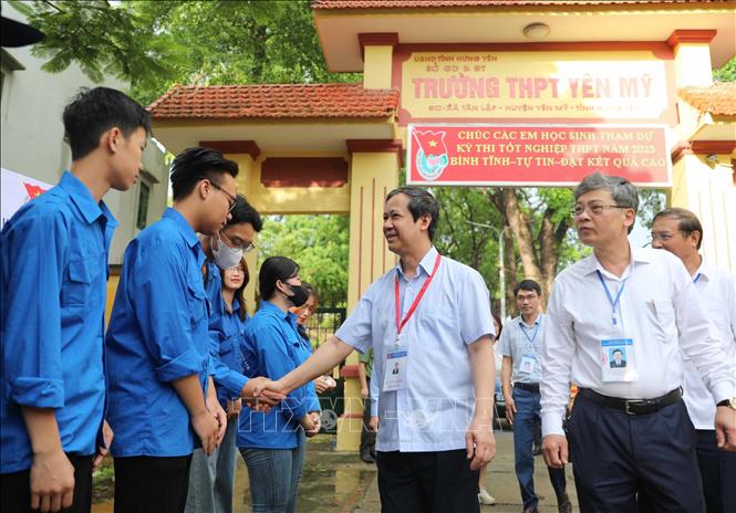 Bộ trưởng Bộ Giáo dục và Đào tạo Nguyễn Kim Sơn hỏi thăm, động viên thanh niên tình nguyên tham gia hỗ trợ kỳ thi tại điểm thi Trường THPT Yên Mỹ (huyện Yên Mỹ, Hưng Yên). Ảnh: Thanh Tùng - TTXVN