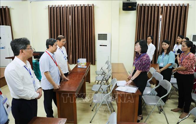Bộ trưởng Bộ Giáo dục và Đào tạo Nguyễn Kim Sơn nghe báo cáo công tác coi thi tại điểm thi Trường THPT Yên Mỹ (huyện Yên Mỹ, Hưng Yên). Ảnh: Thanh Tùng - TTXVN