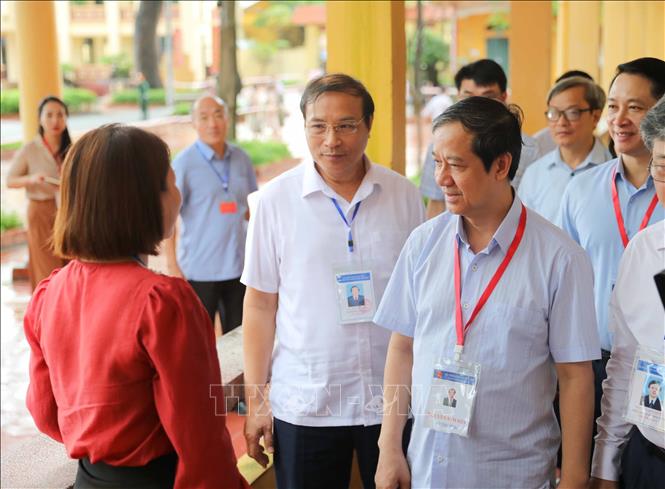 Bộ trưởng Bộ Giáo dục và Đào tạo Nguyễn Kim Sơn trao đổi với cán bộ coi thi tại điểm thi Trường THPT Yên Mỹ (huyện Yên Mỹ, Hưng Yên). Ảnh: Thanh Tùng - TTXVN