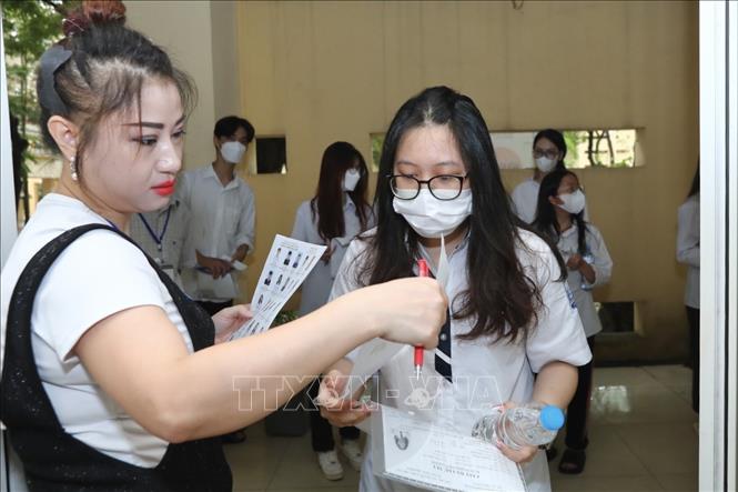 Giám thị gọi thí sinh vào phòng thi tại điểm thi trường THPT Nguyễn Gia Thiều (Hà Nội). Ảnh: Minh Quyết - TTXVN