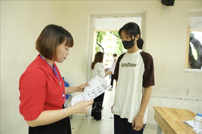 Giám thị gọi thí sinh vào phòng thi tại điểm thi trường THPT Nguyễn Gia Thiều (Hà Nội). Ảnh: Minh Quyết - TTXVN
