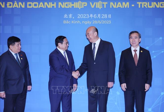 Prime Minister Pham Minh Chinh (2nd L) and Chinese Vice Premier Liu Guozhong (2nd R) at  the Vietnam-China Trade and Investment Cooperation Forum in Beijing on June 28. VNA Photo: Dương Giang
