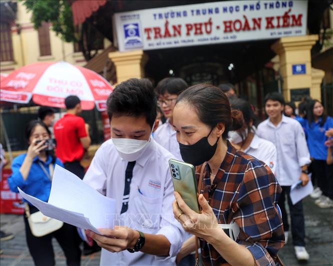 Thí sinh trao đổi bài làm với phụ huynh tại điểm thi trường THPT Trần Phú. Ảnh: Tuấn Đức - TTXVN