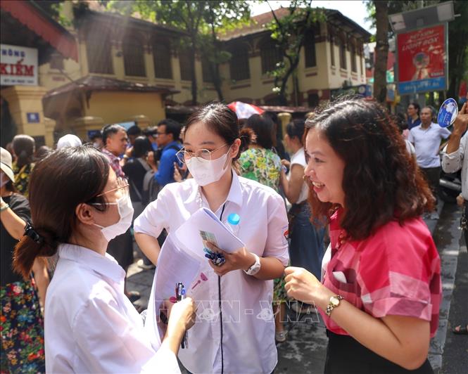 Các thí sinh trao đổi bài làm với phụ huynh tại điểm thi trường THPT Trần Phú. Ảnh: Tuấn Đức - TTXVN