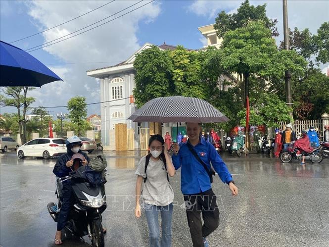 Trong ảnh: Thanh niên tình nguyện hỗ trợ thí sinh sáng 28/6. Ảnh: Mạnh Minh - TTXVN