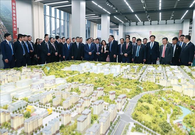 Thủ tướng Phạm Minh Chính xem sa bàn quy hoạch tổng thể Khu mới Hùng An. Ảnh: Dương Giang-TTXVN
