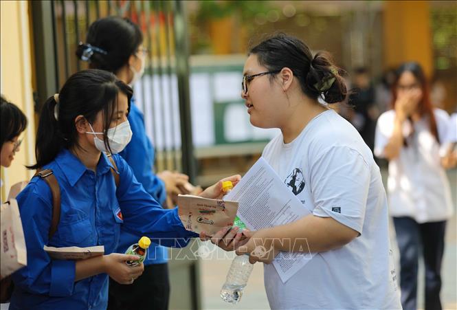Tình nguyện viên gửi tặng bánh, món quà tinh thần chúc mừng thí sinh hoàn thành kỳ thi. Ảnh: Thanh Tùng - TTXVN