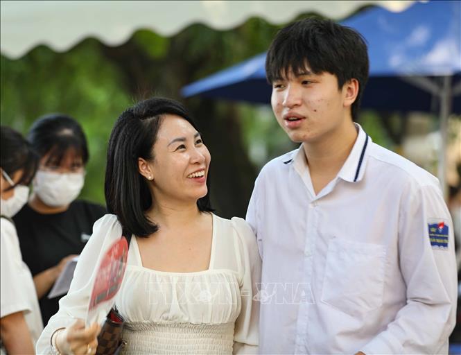 Phụ huynh phấn khởi đón thí sinh sau khi hoàn thành môn thi cuối cùng tại điểm thi trường THPT Trần Nhân Tông, quận Hai Bà Trưng. Ảnh: Thanh Tùng - TTXVN 
