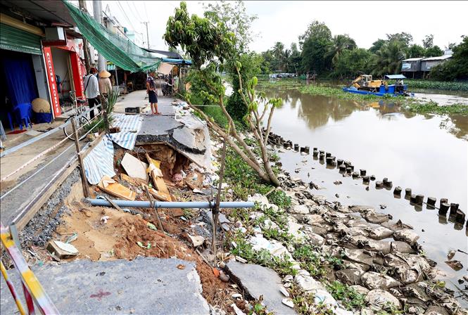 Trong ảnh: Sạt lở đường giao thông cặp sông Cần Lố, qua chợ trung tâm xã Nhị Mỹ, huyện Cao Lãnh, tỉnh Đồng Tháp. Ảnh: Hồng Đạt - TTXVN
