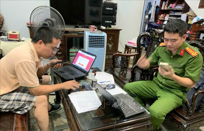 Trong ảnh: Công an phường Đông Ngạc đến từng nhà hỗ trợ người dân kích hoạt định danh điện tử. Ảnh: TTXVN phát