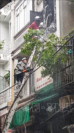 Lực lượng chức năng phải phá cửa để đưa vòi nước vào trong nhà dập lửa. Ảnh: Tuấn Anh - TTXVN