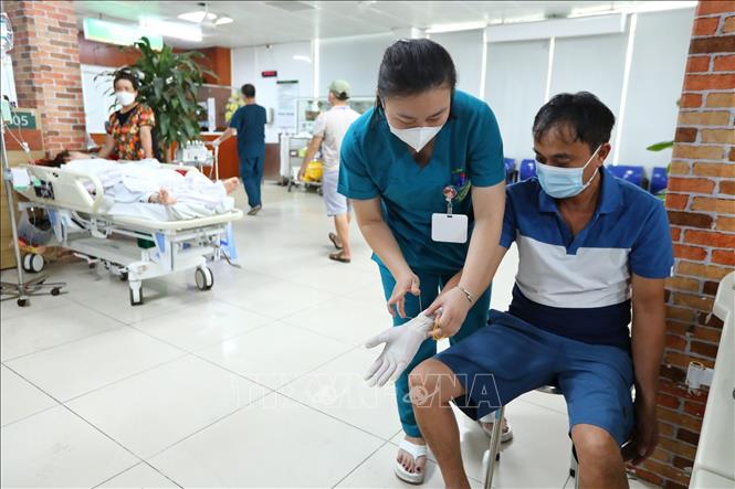 Bác sĩ Trung tâm Chống độc Bệnh viện Bạch Mai khám cho bệnh nhân bị ngộ độc khi tiếp xúc với nước rửa kính mua trên mạng không rõ nguồn gốc. Ảnh: Minh Quyết – TTXVN