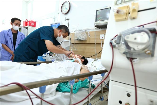 Tiến sỹ Nguyễn Trung Nguyên, Giám đốc Trung tâm Chống độc Bệnh viện Bạch Mai thăm khám cho bệnh nhân nặng đang điều trị tại Trung tâm. Ảnh: Minh Quyết – TTXVN