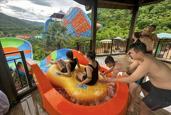 Trong ảnh: Khách du lịch vui chơi tại Công viên suối khoáng nóng Núi Thần Tài. Ảnh: Trần Lê Lâm - TTXVN 