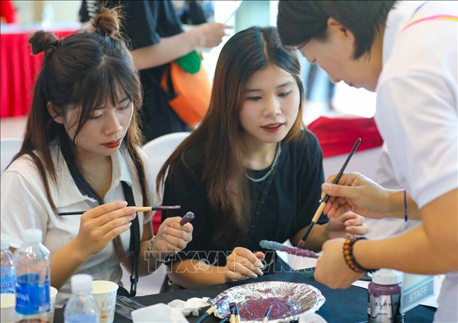 Sinh viên cùng cán bộ, giảng viên Đại học Kunjang giao lưu, tìm hiểu văn hóa và làm các sản phẩm thủ công độc đáo. Ảnh: Thanh Tùng - TTXVN 